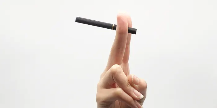 人差し指と中指をピンと伸ばしてタバコを持つ手