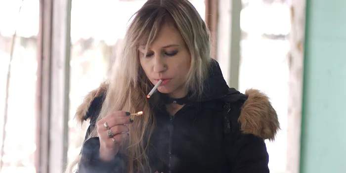 タバコに火をつける女性