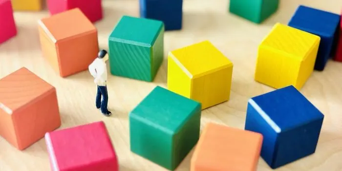 カラフルなブロックの前に立つミニチュア男性